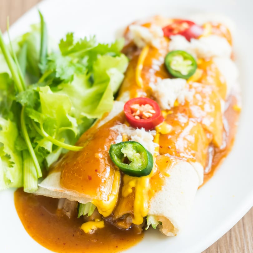 Rose's Mexican Restaurant enchiladas with red sauce, cheese, jalapeños, and cilantro on a white plate.