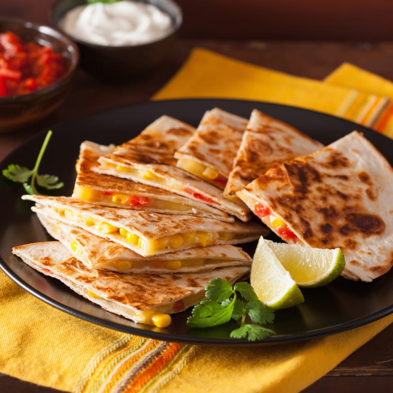 Rose's Mexican Restaurant quesadillas with corn and peppers, garnished with lime and cilantro.